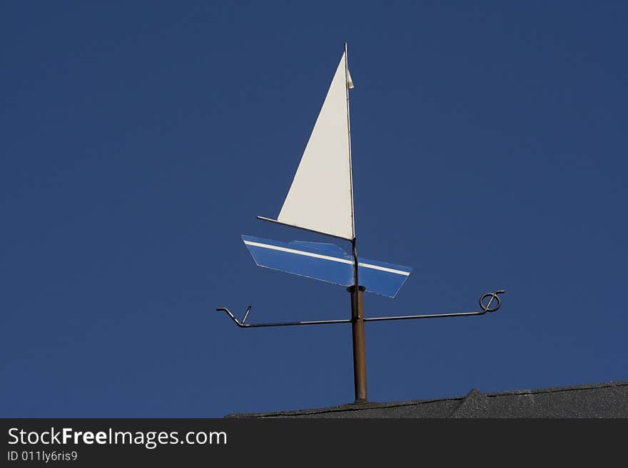 Weather vane - Blue boat - against the blue sky