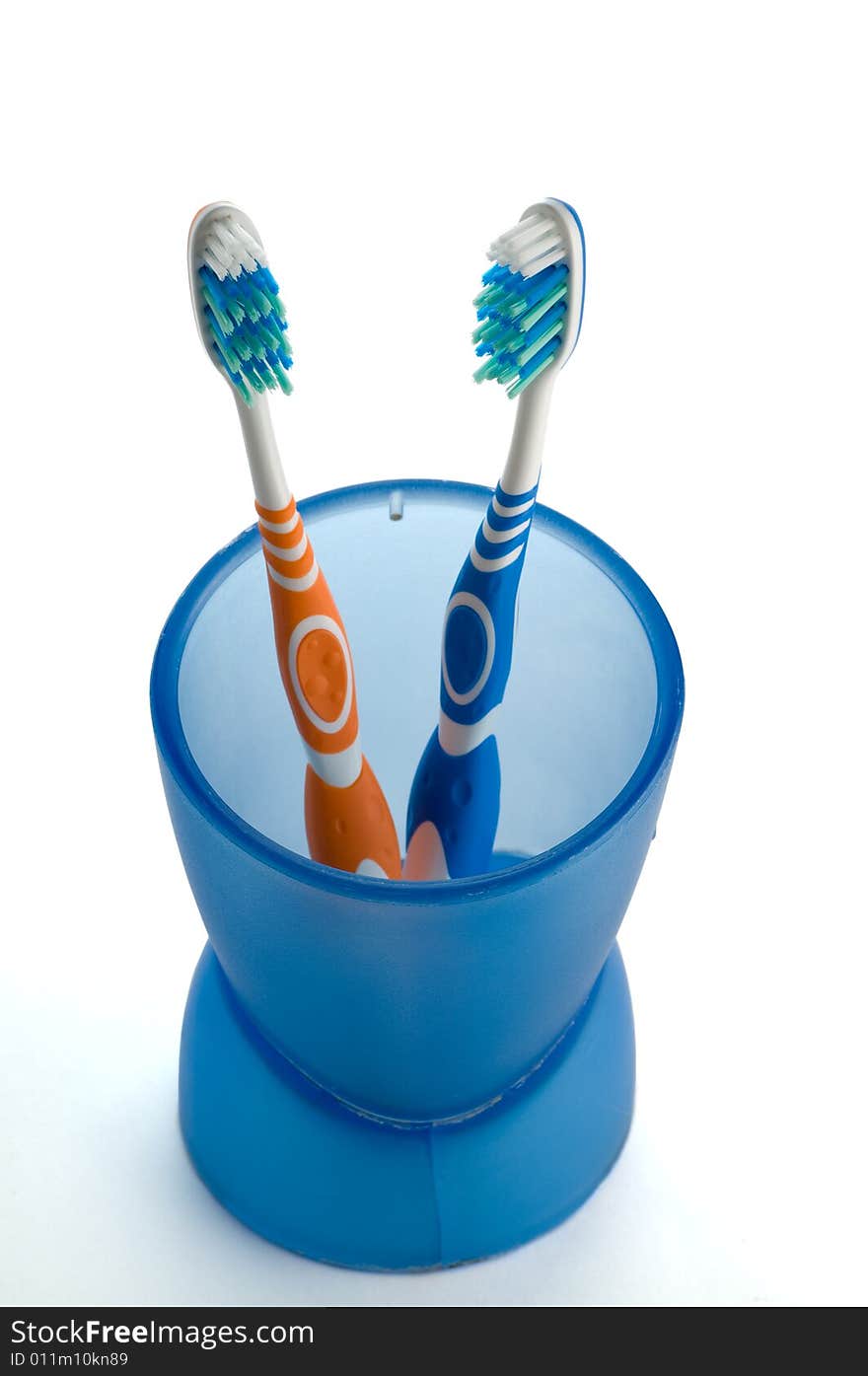 Two Toothbrushes In Blue Cup