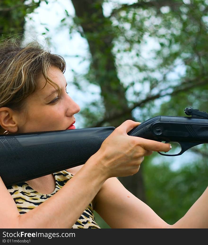 Girl with gun in wood