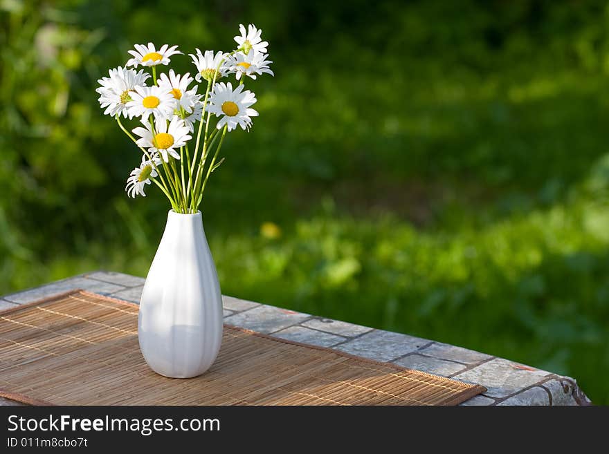 White flowers in white vase on the table