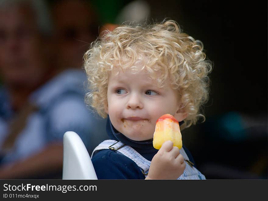 Cute young boy eating ice cream in summer