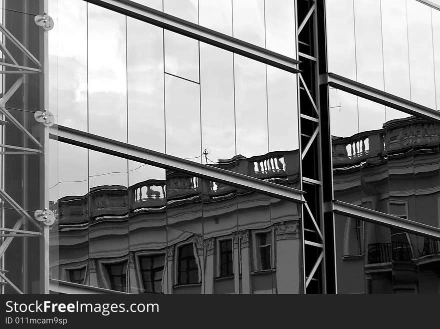 Old house reflected in modern building windows black and white. Old house reflected in modern building windows black and white