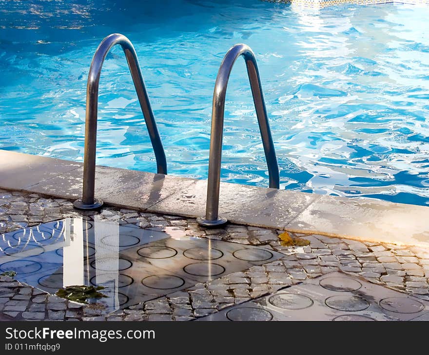 Border of pool and stair, with blue calm water. Border of pool and stair, with blue calm water