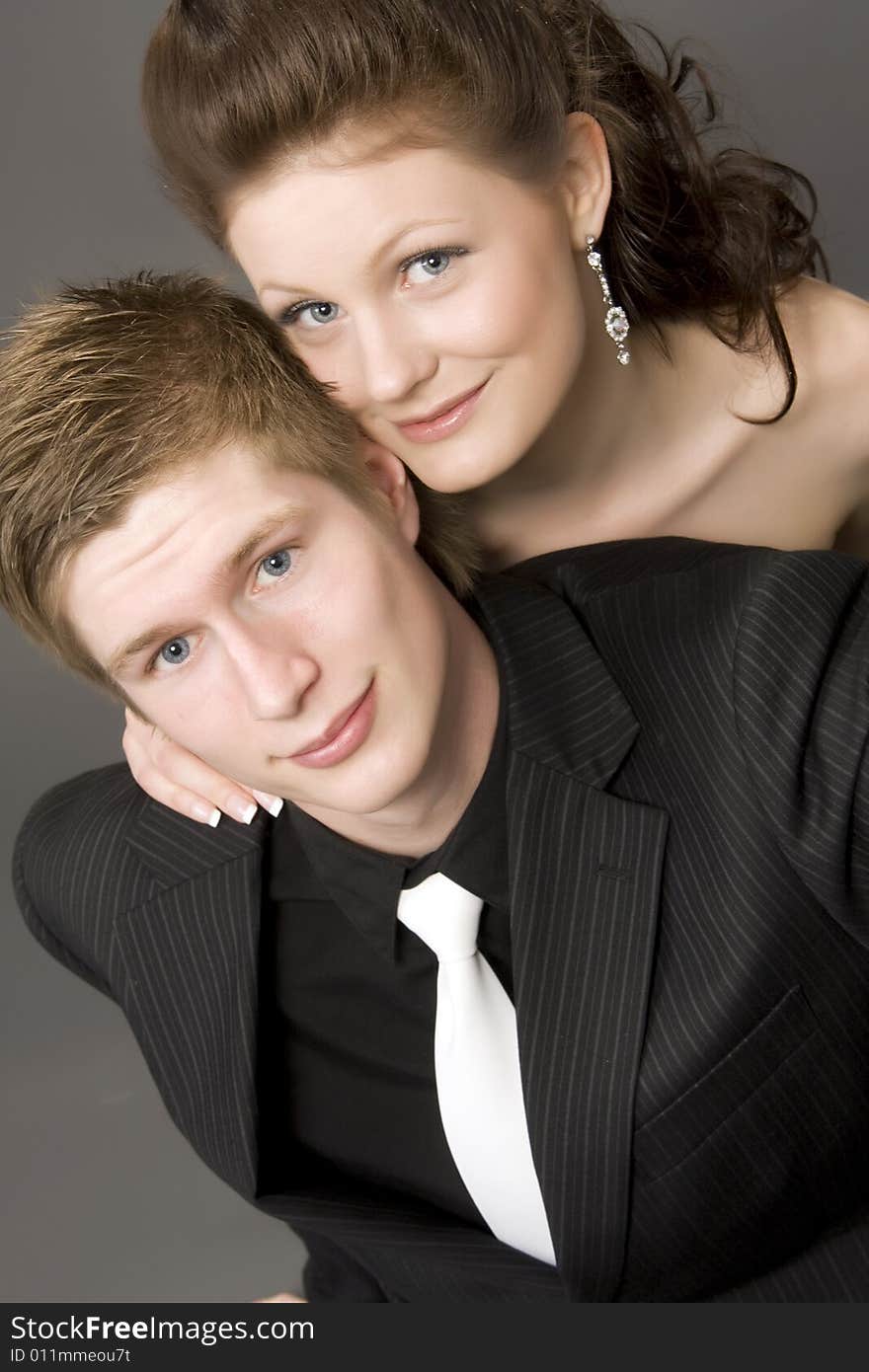 Portrait of a young beautiful couple on gray background