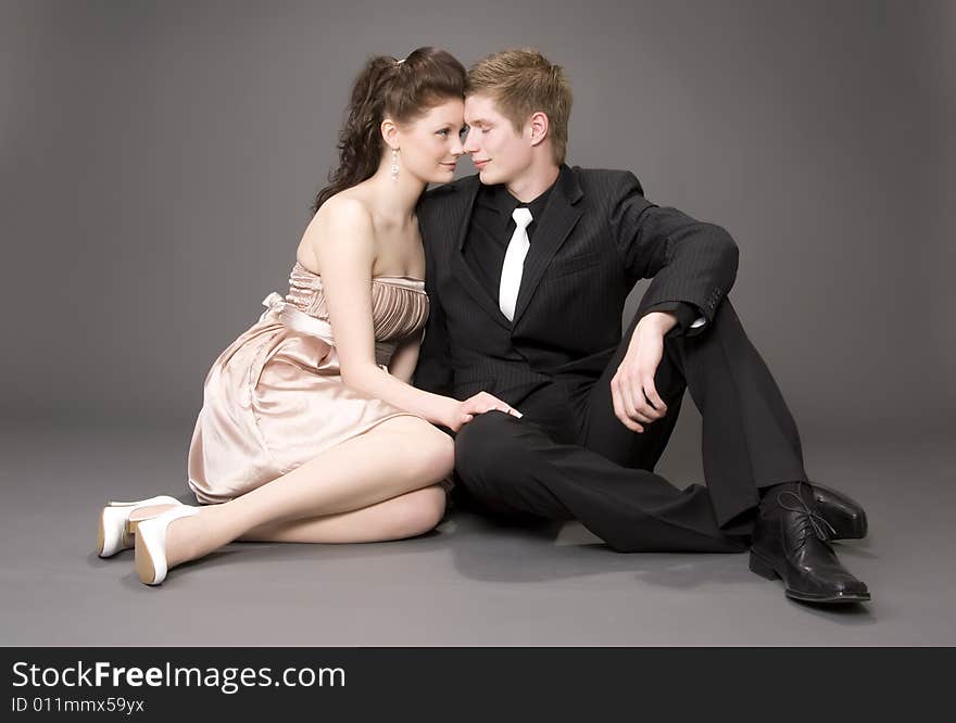 Portrait of a young beautiful couple on gray background