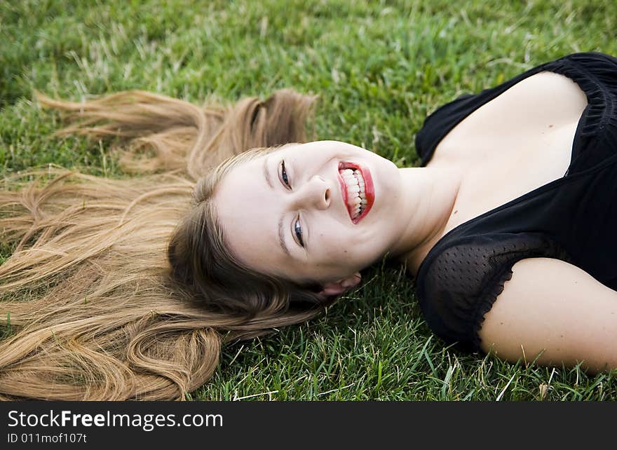 Young laughing girl on green grass