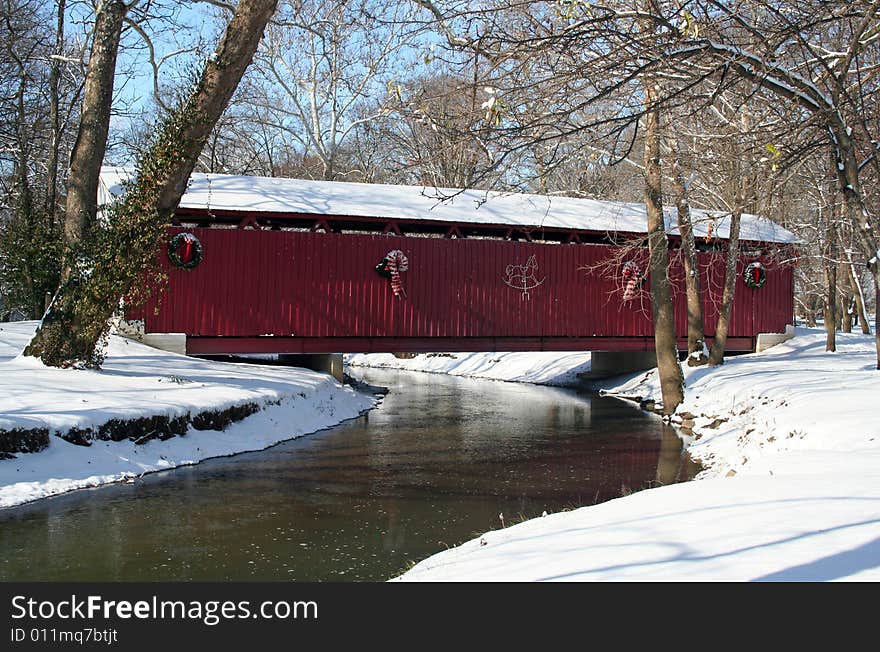 Old covered bridge after a snowfall decorated with christmas lights. Old covered bridge after a snowfall decorated with christmas lights