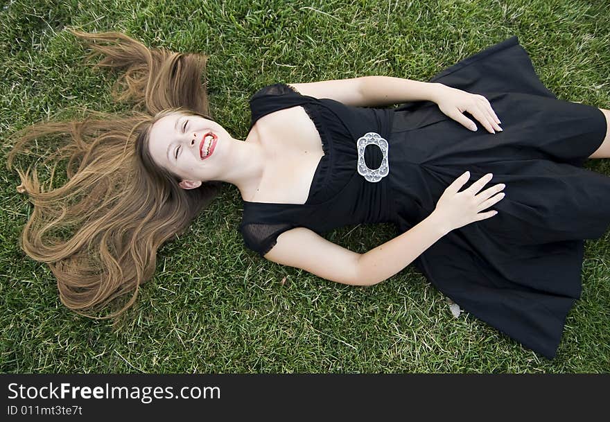 Young laughing girl on green grass