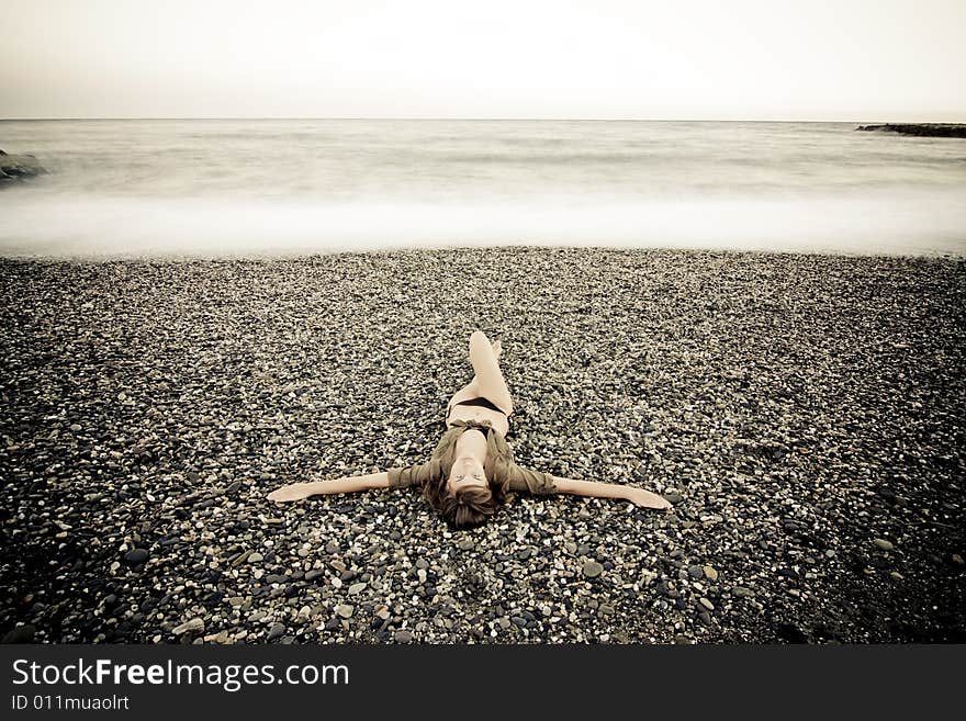 Crucified woman in stone beach, long exposure. Crucified woman in stone beach, long exposure