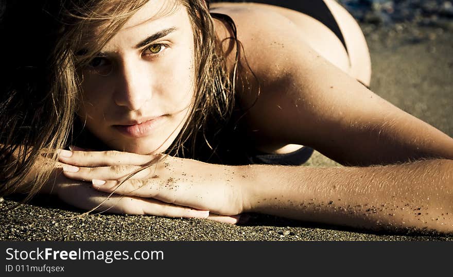 Green eyed beauty laying over the sand. Green eyed beauty laying over the sand