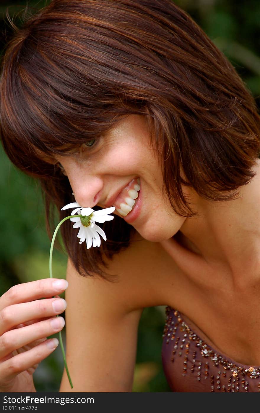 Happy girl smelling a daisy flower. Happy girl smelling a daisy flower