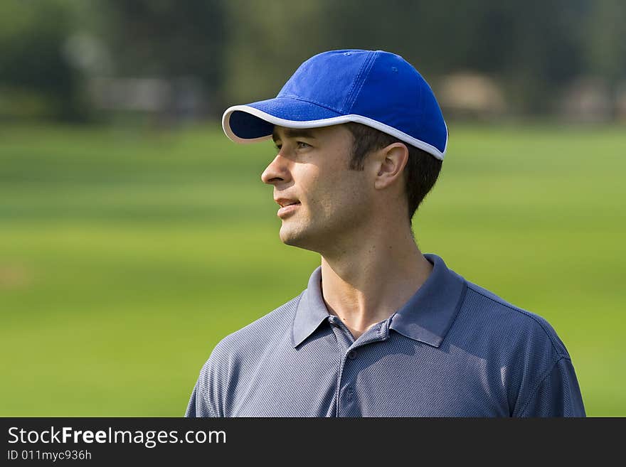 Man's profile while standing on golf course - Horizontally framed photo. Man's profile while standing on golf course - Horizontally framed photo