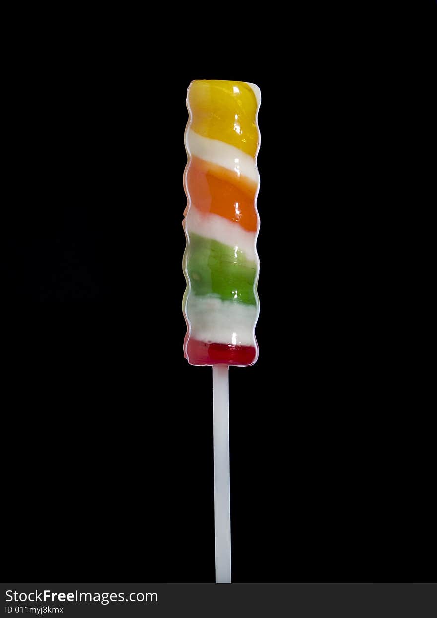 A stick lollipop isolated over black background.