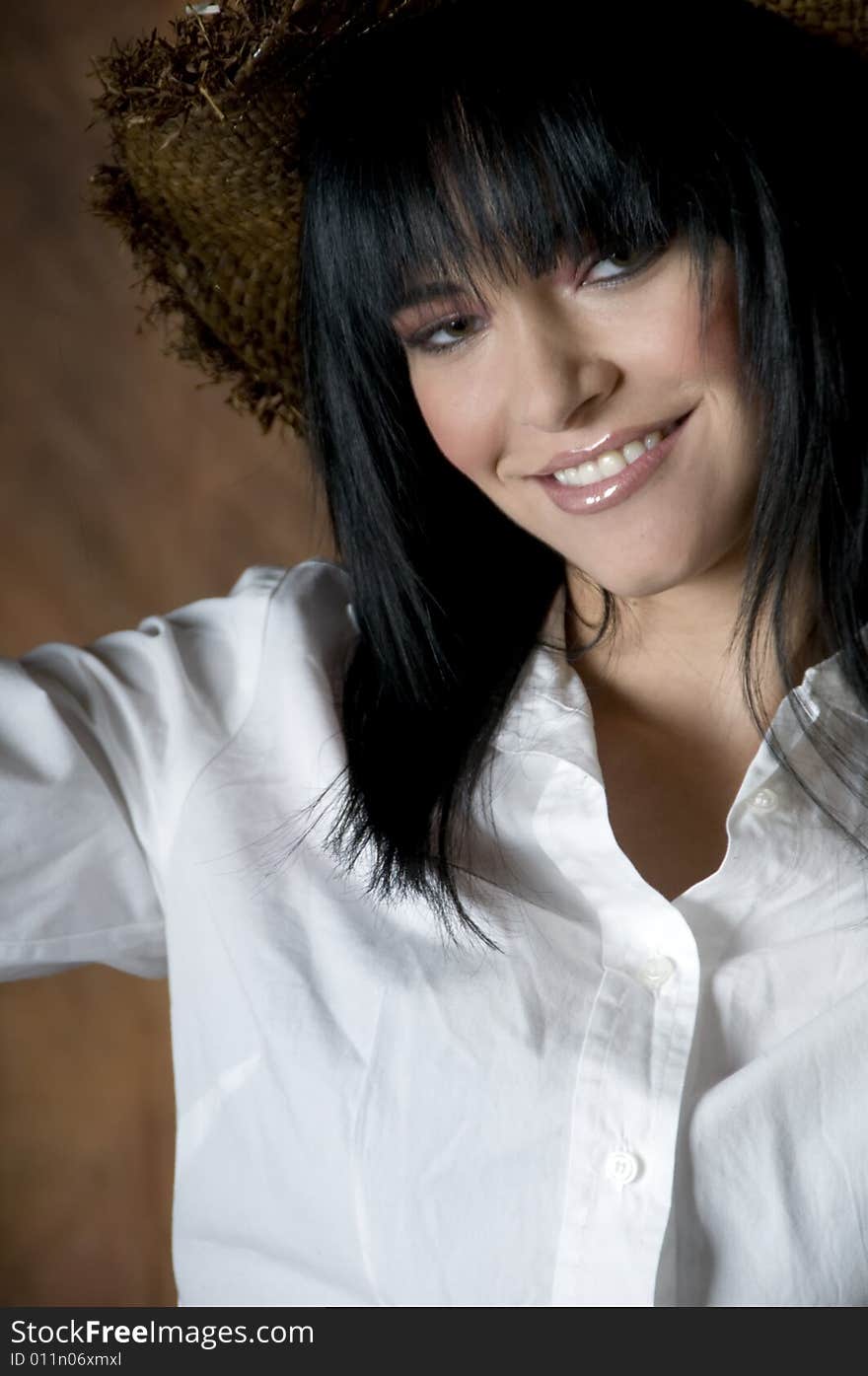 Portrait of a smiling young woman with black hair wearing a white shirt, straw hat and pink lipstick. Portrait of a smiling young woman with black hair wearing a white shirt, straw hat and pink lipstick.