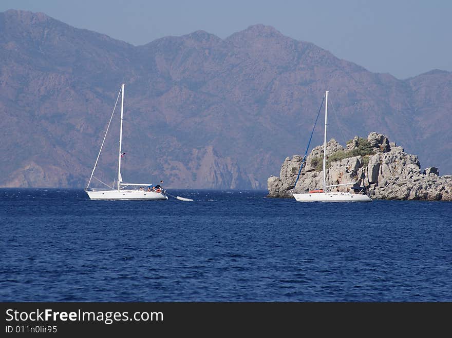 Two sailboats in front of small isle. Two sailboats in front of small isle