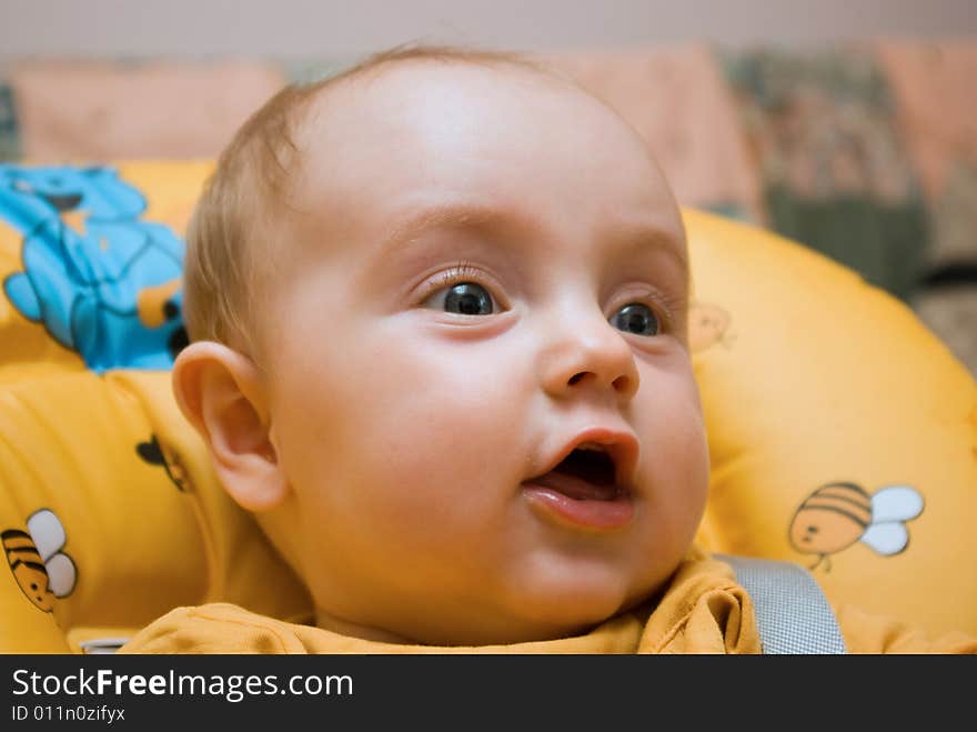 Little baby girl, sitting in a chair, looking happy and surprised. Little baby girl, sitting in a chair, looking happy and surprised