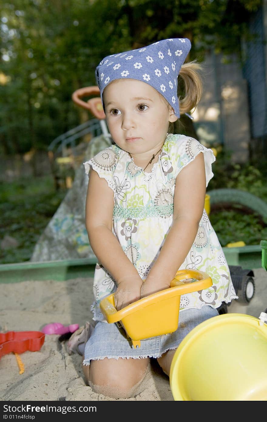 Little girl playing in sandpit