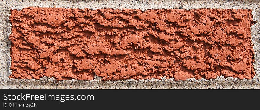 Single red brick surrounded by cement