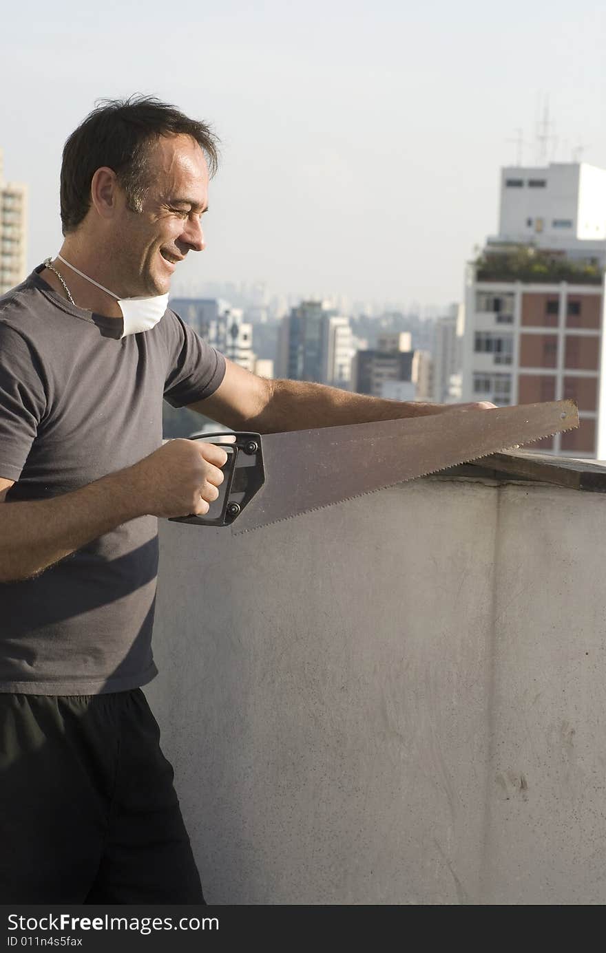 Smiling Man Using Handsaw - Vertical