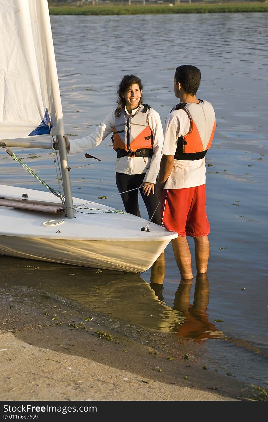 Couple Standing Next to Sailboat - Vertical