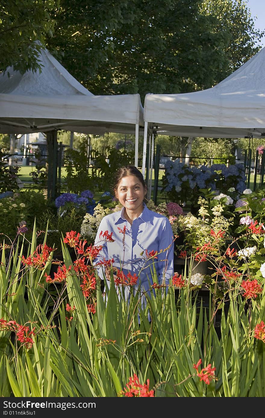 Woman with Flowers Smiling at Camera - Vertical