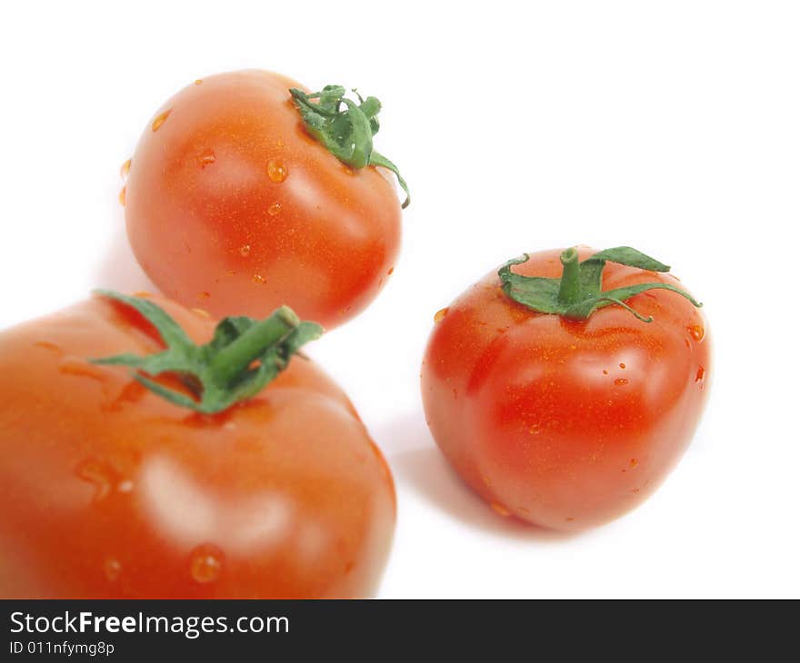 Three fresh red tomatoes with water drops and isolated on white background. Three fresh red tomatoes with water drops and isolated on white background