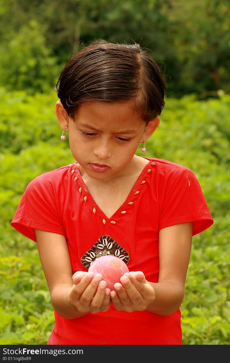 A small girl holding the ball.