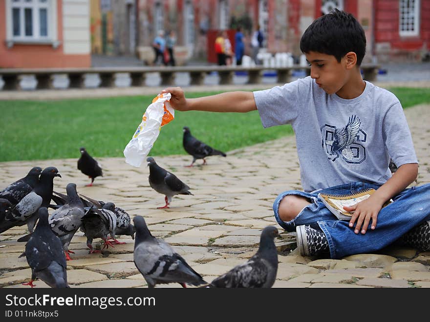 Sharing food with pigeons in the city square