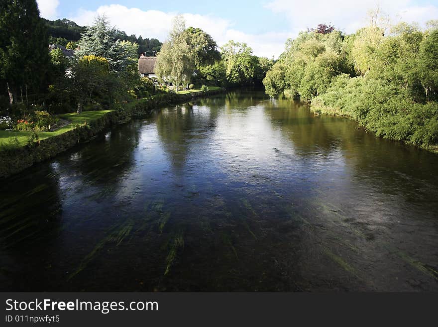 Thatched cottage beside english river. Thatched cottage beside english river