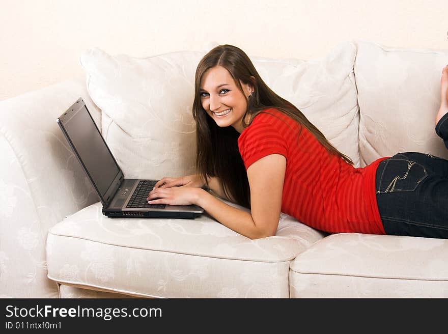 A young beautiful woman with a laptop on a lounge