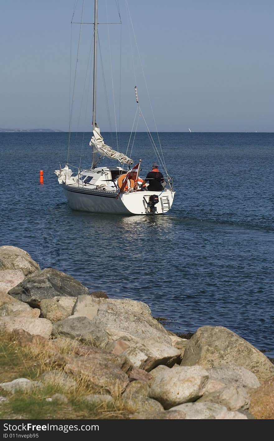 Sailing boat passing buoy outside Norsminde Harbour, Denmark