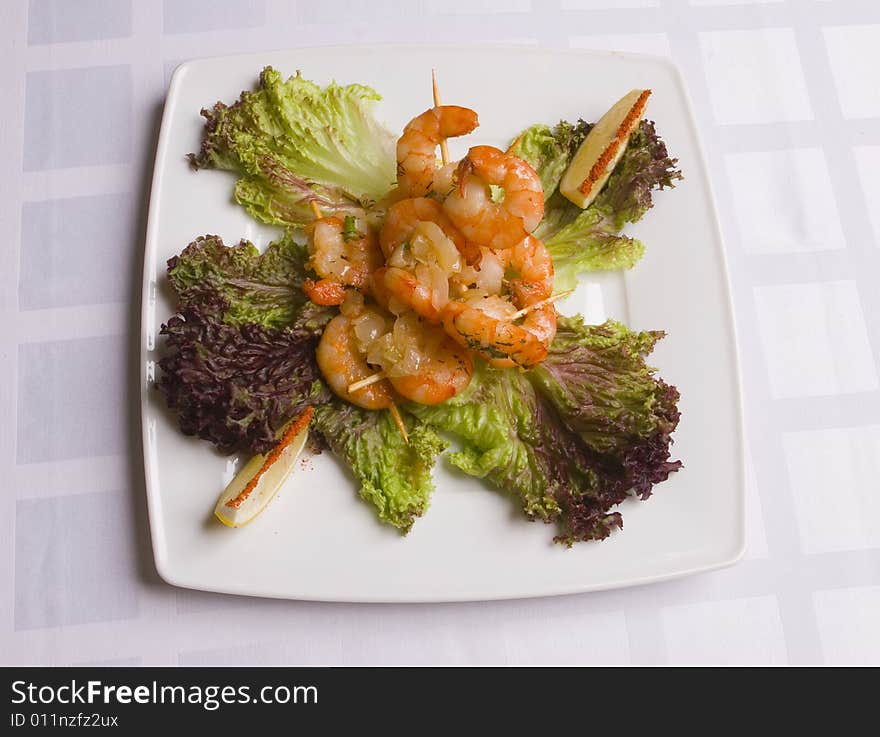 Shrimp's salad with lemon slices on white plate. Shrimp's salad with lemon slices on white plate