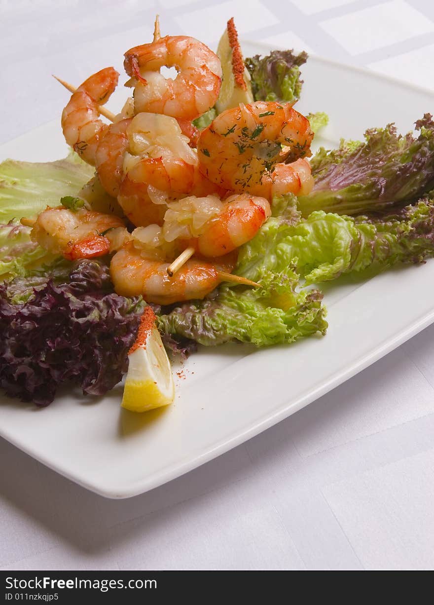 Shrimp's salad with lemon slices on white plate. Shrimp's salad with lemon slices on white plate