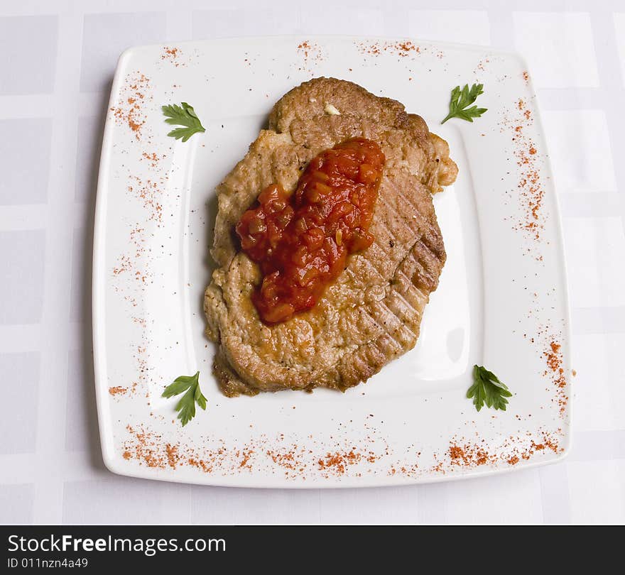 Meal cutlet with tomatoes sauce on white plate