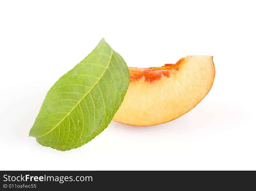 Ripe sliced peach fruit with green leaf isolated on white background. Ripe sliced peach fruit with green leaf isolated on white background