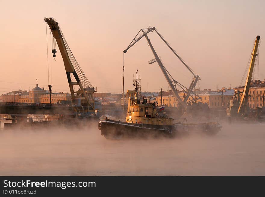 A  small yellow river ice breaker in a port. A  small yellow river ice breaker in a port