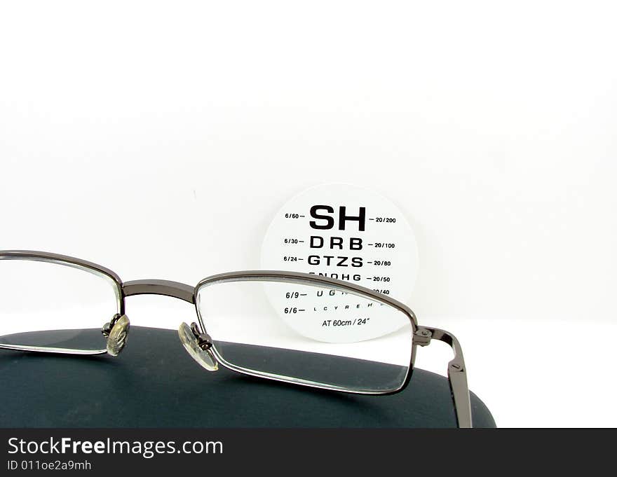 Glasses and eye test isolated over white background, at the optician.