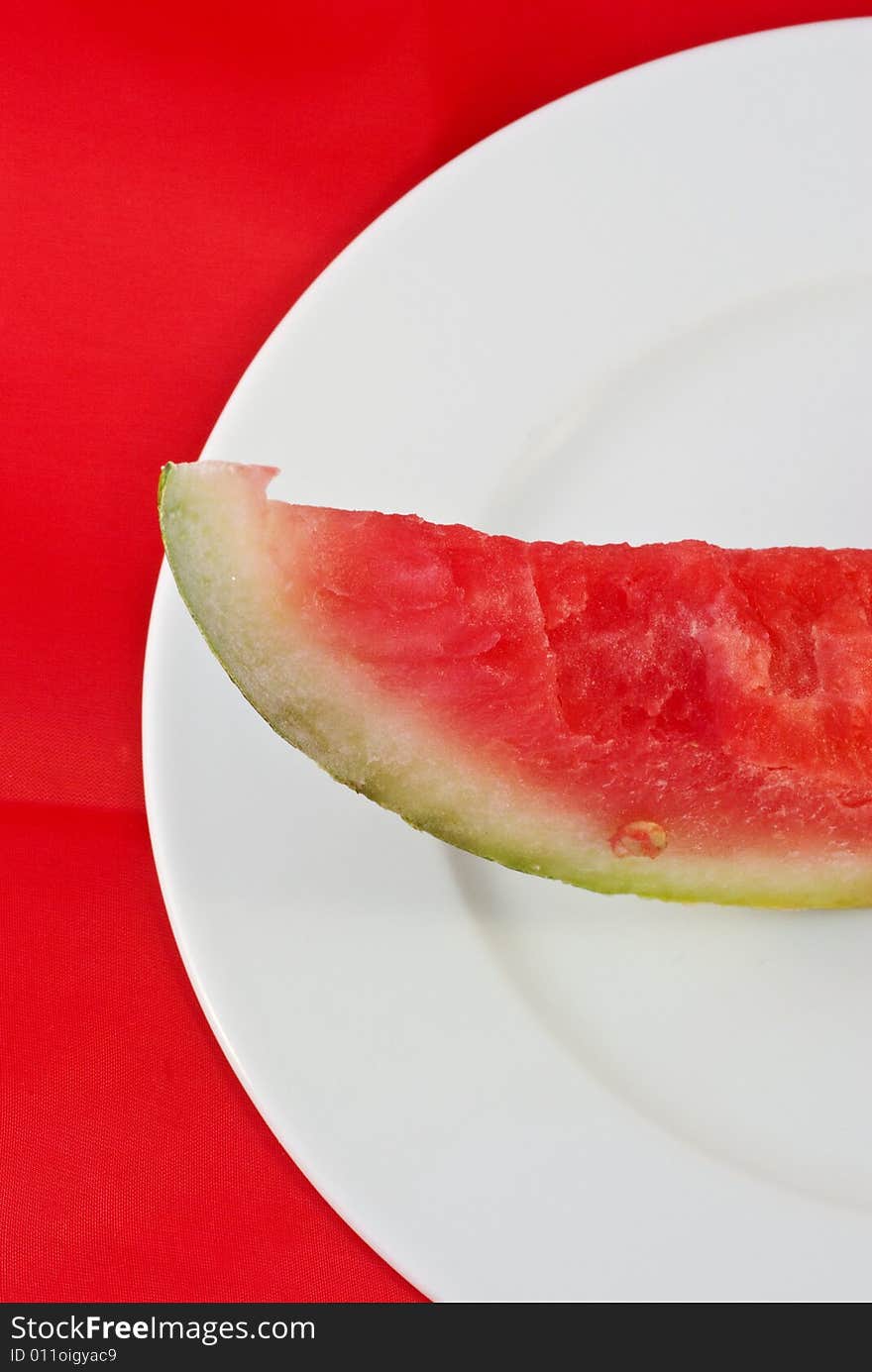 A plate with a peiece of watermelon in a graphical composition. A plate with a peiece of watermelon in a graphical composition