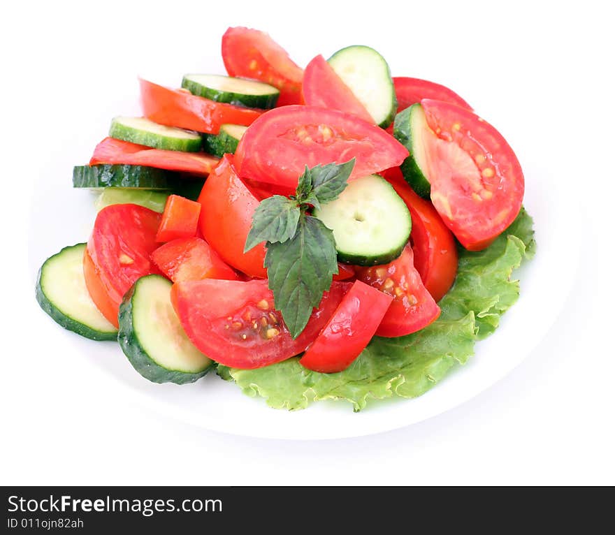 Tomatos and cucumbers and salad on a white background