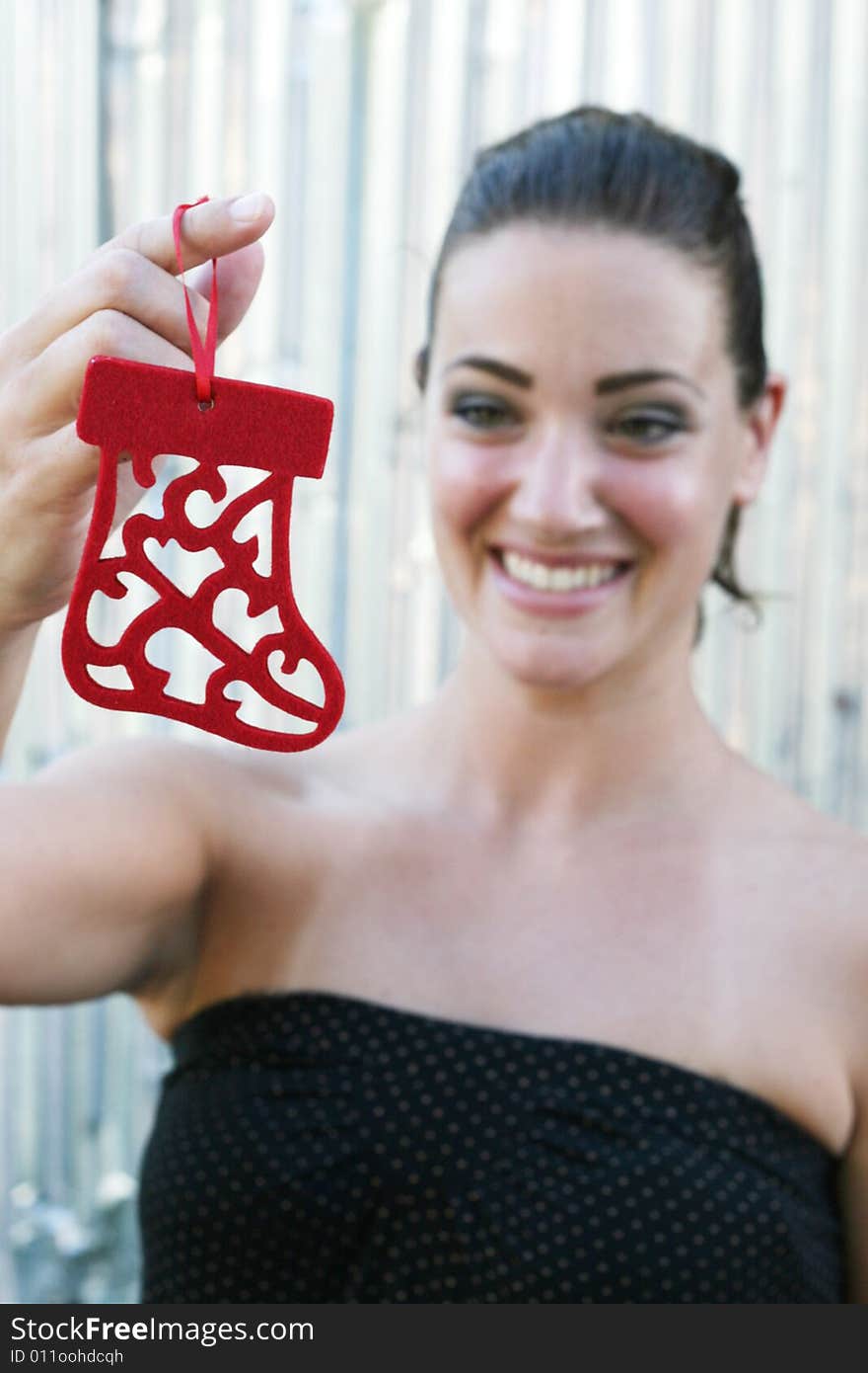 Portrait of a beautiful young brunette woman with a Christmas decoration (focus on decoration). Portrait of a beautiful young brunette woman with a Christmas decoration (focus on decoration).