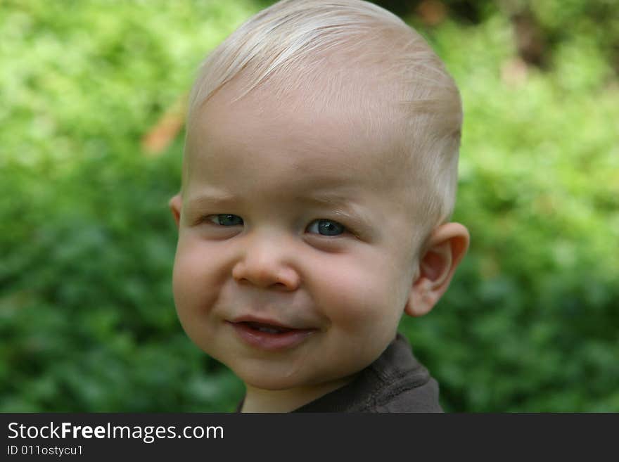 Child toddler has head shot with blond hair is smiling. Child toddler has head shot with blond hair is smiling.