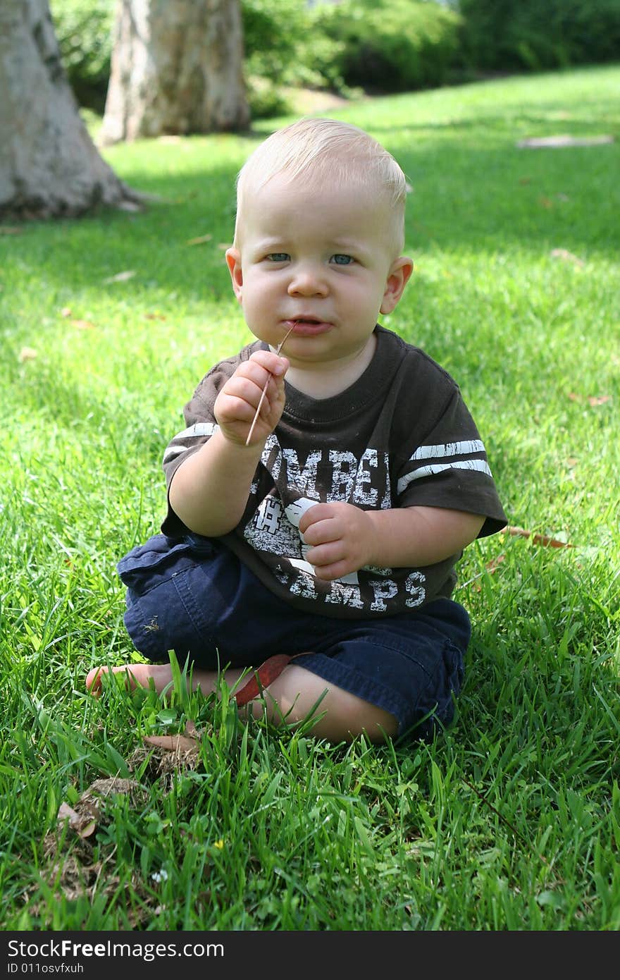 Sitting boy with grass