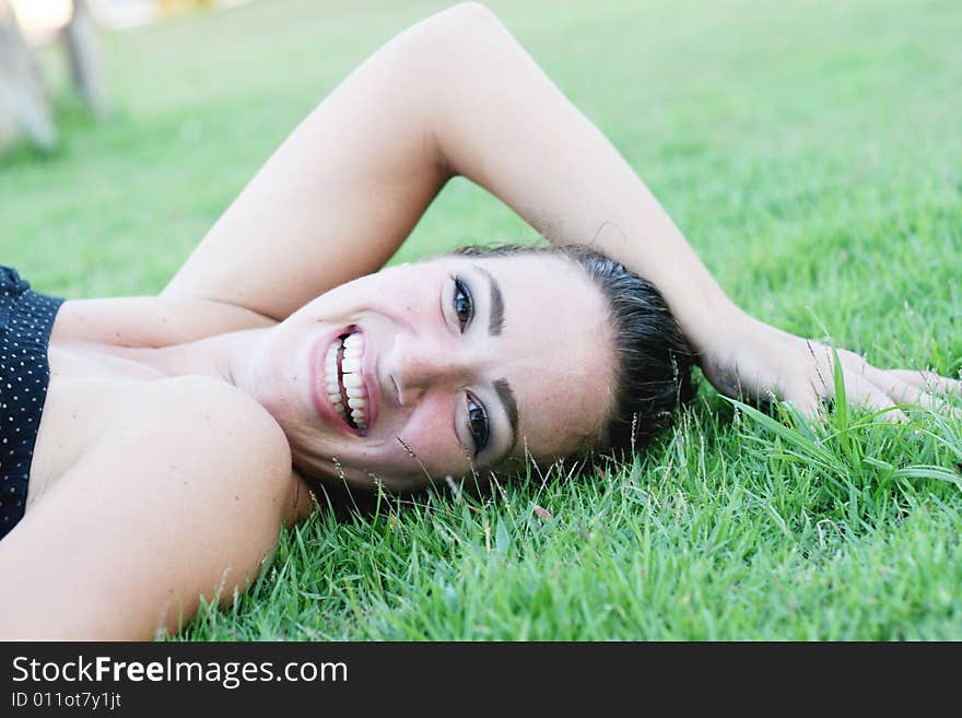 Portrait of a beautiful young woman on the grass. Portrait of a beautiful young woman on the grass.