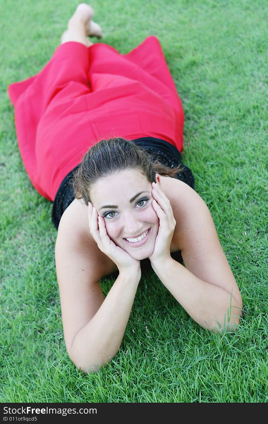 Portrait of a happy woman lying on the grass.