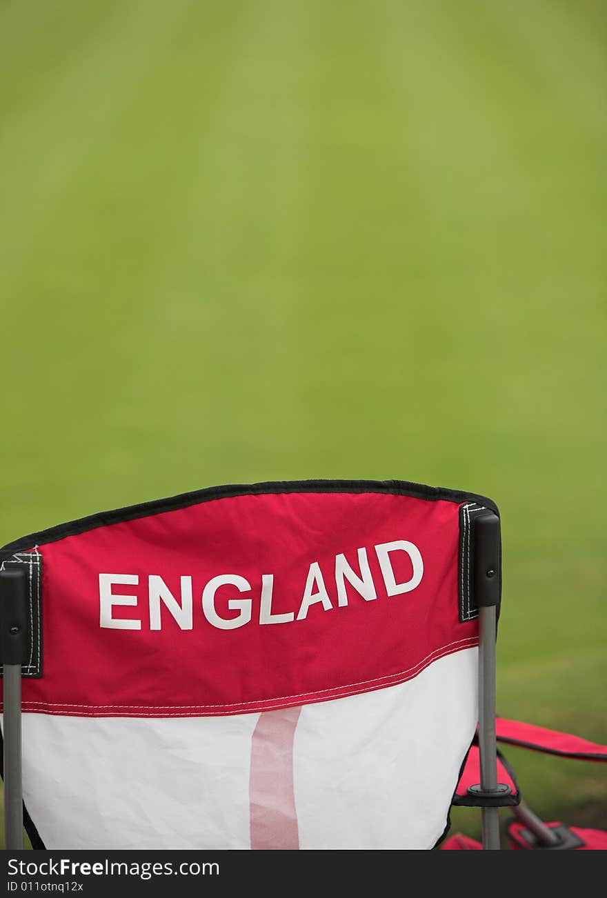 An England chair next to a manicured lawn. An England chair next to a manicured lawn.