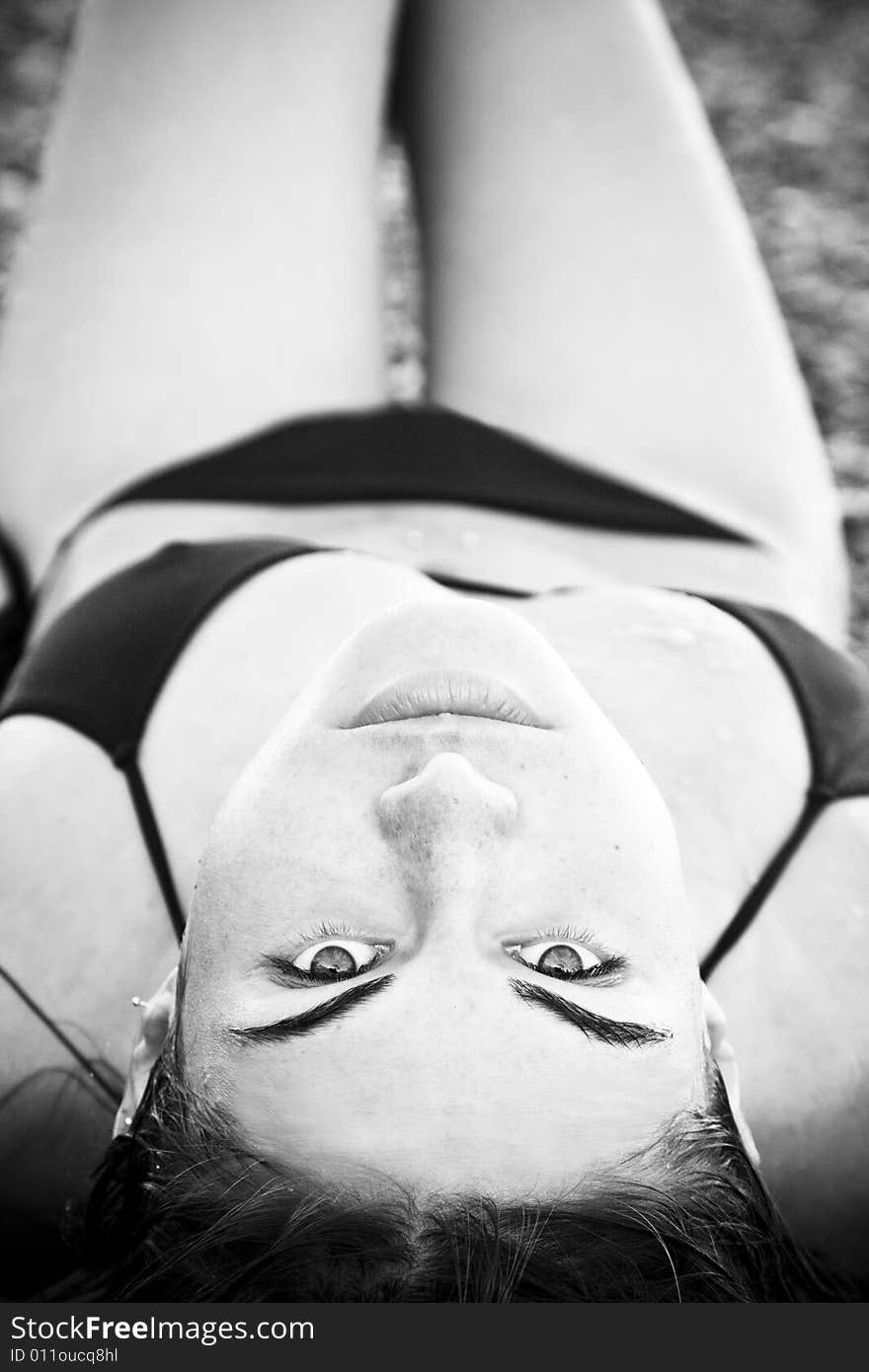 Laying beauty wearing black small bikini.