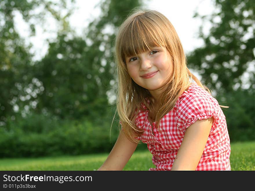 Cute little girl smiling outdoors on summer day