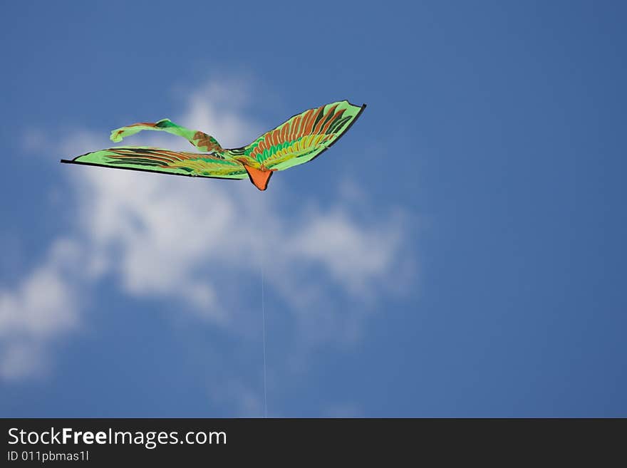 Green kite flying in the blue sky. Green kite flying in the blue sky