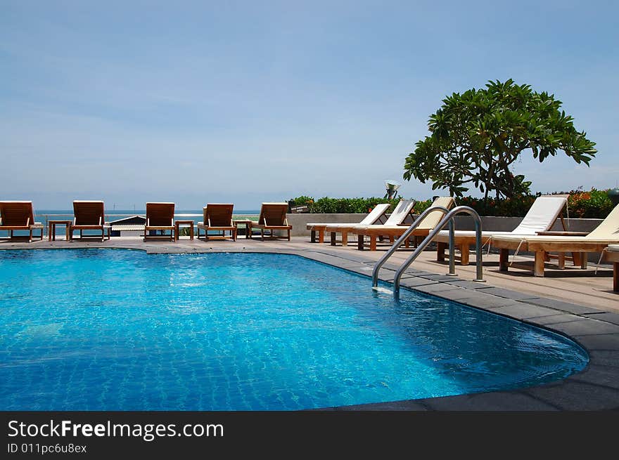 White trestle-beds near the resort's pool. White trestle-beds near the resort's pool