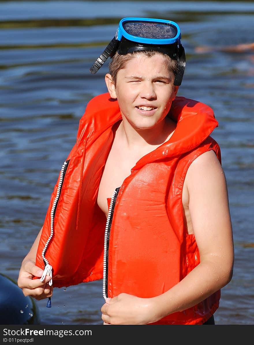 The portrait of the boy with a life-jacket and a diving mask. The portrait of the boy with a life-jacket and a diving mask.